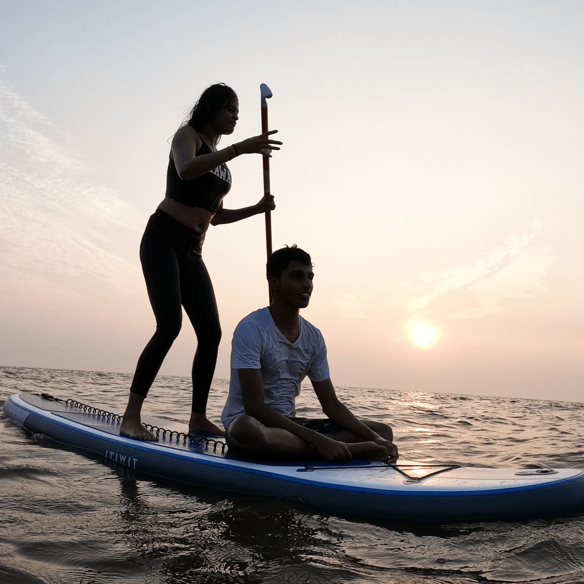 a couple doing stand up paddleboard at rajodi beach